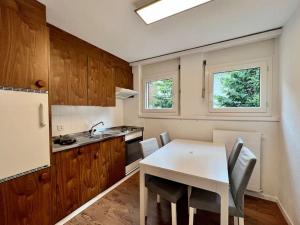a kitchen with a white table and a white refrigerator at Pure Comfort! Entire Apartment with Abundant Space near Zermatt in Täsch