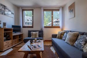 een woonkamer met een blauwe bank en een salontafel bij City center studio next to Aguille du Midi lift in Chamonix-Mont-Blanc