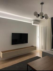 a living room with a flat screen tv on a white wall at AirStay in Prishtinë