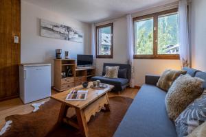 een woonkamer met een blauwe bank en een tafel bij City center studio next to Aguille du Midi lift in Chamonix-Mont-Blanc