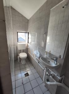 a white bathroom with a toilet and a sink at Park 2 Branka FREE PARKING in Vranje