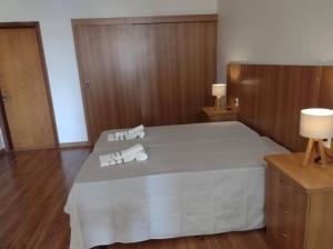 a bedroom with a bed with two towels on it at Chalet Rustico da Elena com Sauna y Jacuzzi Unicep in São Carlos