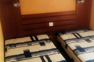 Duas camas individuais num quarto em LOGEMENT AU COEUR DE PYRENEES em Aragnouet
