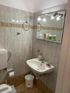 ein Badezimmer mit einem Waschbecken, einem Spiegel und einem WC in der Unterkunft Yalos rooms in Astypalea-Stadt