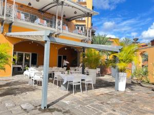 a restaurant with white tables and chairs in front of a building at Cozy one bedroom apartment in a secure complex , PORT CHAMBLY Mauritius in Terre Rouge