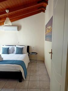 una camera da letto con un letto con cuscini blu e bianchi di Doma Menidi Rooftop Apartment a Menídion