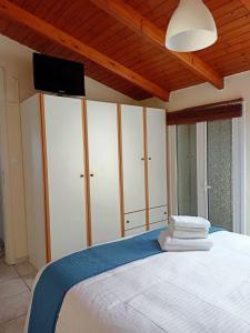 a bedroom with a bed with a tv on the wall at Doma Menidi Rooftop Apartment in Menídion