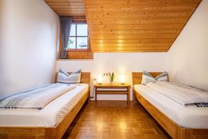 2 Betten in einem Zimmer mit Holzdecken in der Unterkunft Drei-mädelhaus Ambs Wohnung 3 