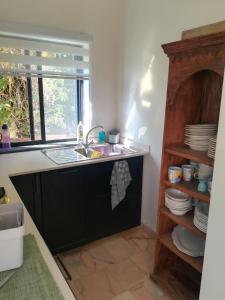 cocina con fregadero y encimera con ventana en Casa Ritmo do Mar, en Quatrim do Sul