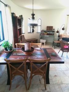 comedor con mesa de madera y sillas en Casa Ritmo do Mar, en Quatrim do Sul