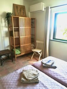 1 dormitorio con 1 cama, 1 silla y 1 ventana en Casa Ritmo do Mar, en Quatrim do Sul