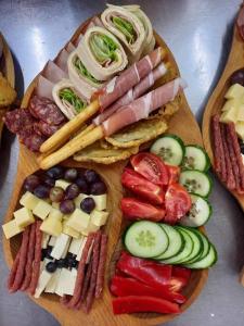 a wooden cutting board topped with different types of food at Bingyó Vendégház in Lupeni