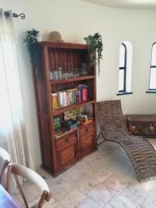 Habitación con estante para libros y silla en Casa Ritmo do Mar, en Quatrim do Sul