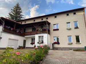 a large house with flowers in front of it at Penzion U Martina in Mariánské Lázně