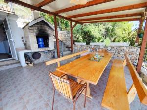 a wooden table and chairs on a patio with a fireplace at Robinson Olympos in Gdinj