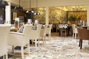a restaurant with white chairs and tables and a wall mural at The Swan Hotel in Bibury