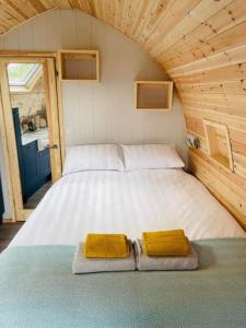 uma cama num pequeno quarto com duas toalhas em Beach House Pods em Dunoon
