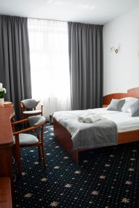 una camera d'albergo con letto e sedia di Hotel Restauracja Autos a Solec Kujawski