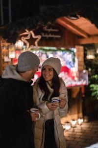 een man en vrouw die naast elkaar staan en koffiekopjes vasthouden bij Hotel Seevilla Wolfgangsee in St. Wolfgang