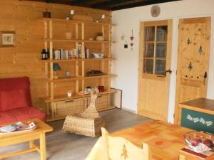 sala de estar con sofá rojo y paredes de madera en Chalanche, en Barcelonnette