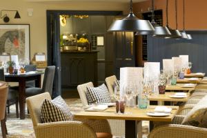 a restaurant with wooden tables and chairs with glasses at The Swan Hotel in Bibury