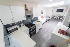 a kitchen with white appliances and a living room at Studio close to Selly Oak train station in Birmingham