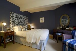 a bedroom with a large bed and a mirror at The Swan Hotel in Bibury