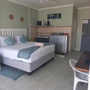 a bedroom with a large bed and a kitchen at Zufike Self Catering in Port Elizabeth