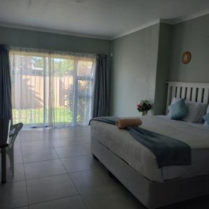 a bedroom with two beds and a large window at Zufike Self Catering in Port Elizabeth