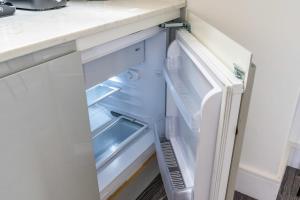 un réfrigérateur vide avec une porte ouverte dans l'établissement Gorgeous Hampstead Flat, à Londres