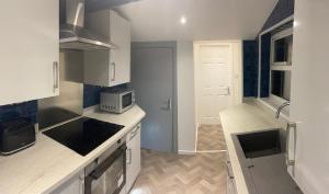 eine Küche mit einer Spüle und einer Mikrowelle in der Unterkunft Contractors House-Welcomes All in South Shields