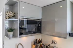 una cocina con microondas sobre un fregadero en Gorgeous Hampstead Flat en Londres