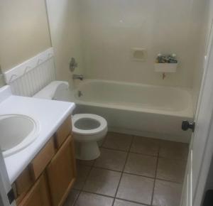 a bathroom with a tub and a toilet and a sink at Karaboapartlodge in Jane Furse +38 photos