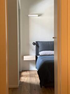 a bedroom with a blue bed and a wooden floor at Mansarda Malenca in Chiesa in Valmalenco