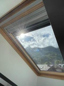 uma janela num quarto com vista para uma montanha em Mansarda Malenca em Chiesa in Valmalenco