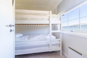 a bedroom with bunk beds and a window at Arctic Lodging North Cape in Skarsvåg