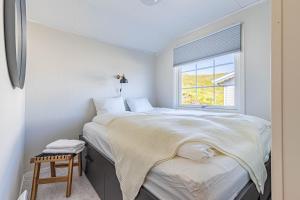 1 dormitorio con cama y ventana en Arctic Lodging North Cape, en Skarsvåg