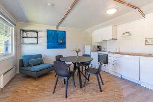 a kitchen and dining room with a table and chairs at Arctic Lodging North Cape in Skarsvåg