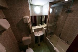 a bathroom with a sink and a shower and a toilet at Hotel Aurora in Satu Mare