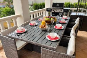 a table with food and wine glasses on a patio at Casa Rose - 4-Bed villa with private pool in Calpe in Calpe
