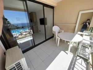 a room with a table and chairs and a balcony at EXCEPTIONNEL sur CANNES vue mer piscine in Cannes