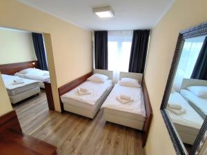 a small room with two beds and a mirror at Hotel SiLL in Kielce