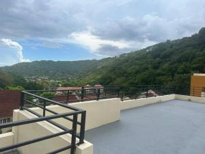 a balcony with a view of a mountain at Luxury Comfy Penthouse Red hills in Kingston