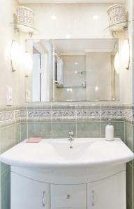 bagno con lavandino bianco e specchio di Centrum - Smocza 20 a Varsavia