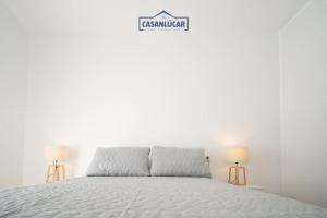 Un dormitorio blanco con una cama y un cartel que dice discusión. en Alcoba 17, en Sanlúcar de Barrameda