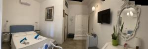 フォンターネ・ビアンケにあるCasa Himera Fontane Biancheの白い部屋(ベッド1台、鏡付)