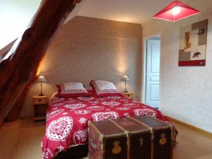 a bedroom with a red bed with a trunk on it at La Boucle de l'Adour Chambres d'Hôtes & gîtes in Campan