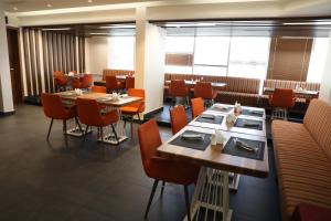 un comedor con mesas, sillas y ventanas en Best Level Hotel, en Yeda