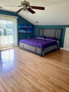 a bedroom with a purple bed and a ceiling fan at Stafford Virginia Stay in Stafford