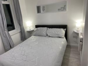 ein weißes Bett in einem Schlafzimmer mit zwei Lampen in der Unterkunft Contractors House-Welcomes All in South Shields